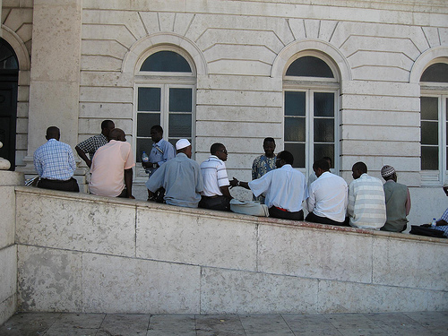 grupo de africanos sentados de espaldas en un edifico público